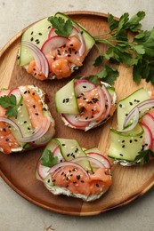 Tasty canapes with salmon served on light grey table, top view