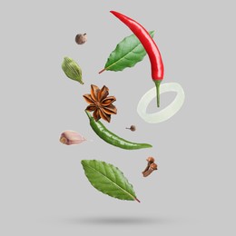 Image of Different spices falling on light grey background