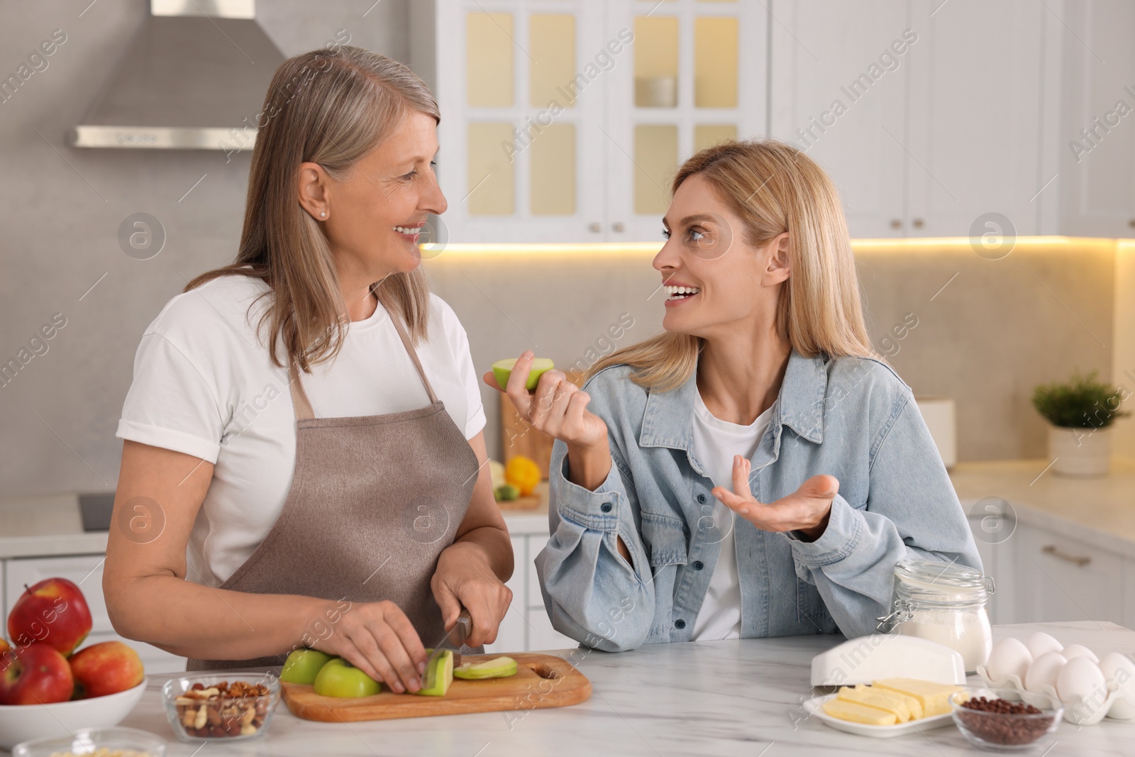 Photo of Happy mature mother and her daughter in kitchen