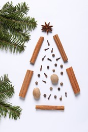 Christmas tree made of different spices and fir branches on white table, flat lay