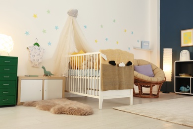 Photo of Stylish baby room interior with crib