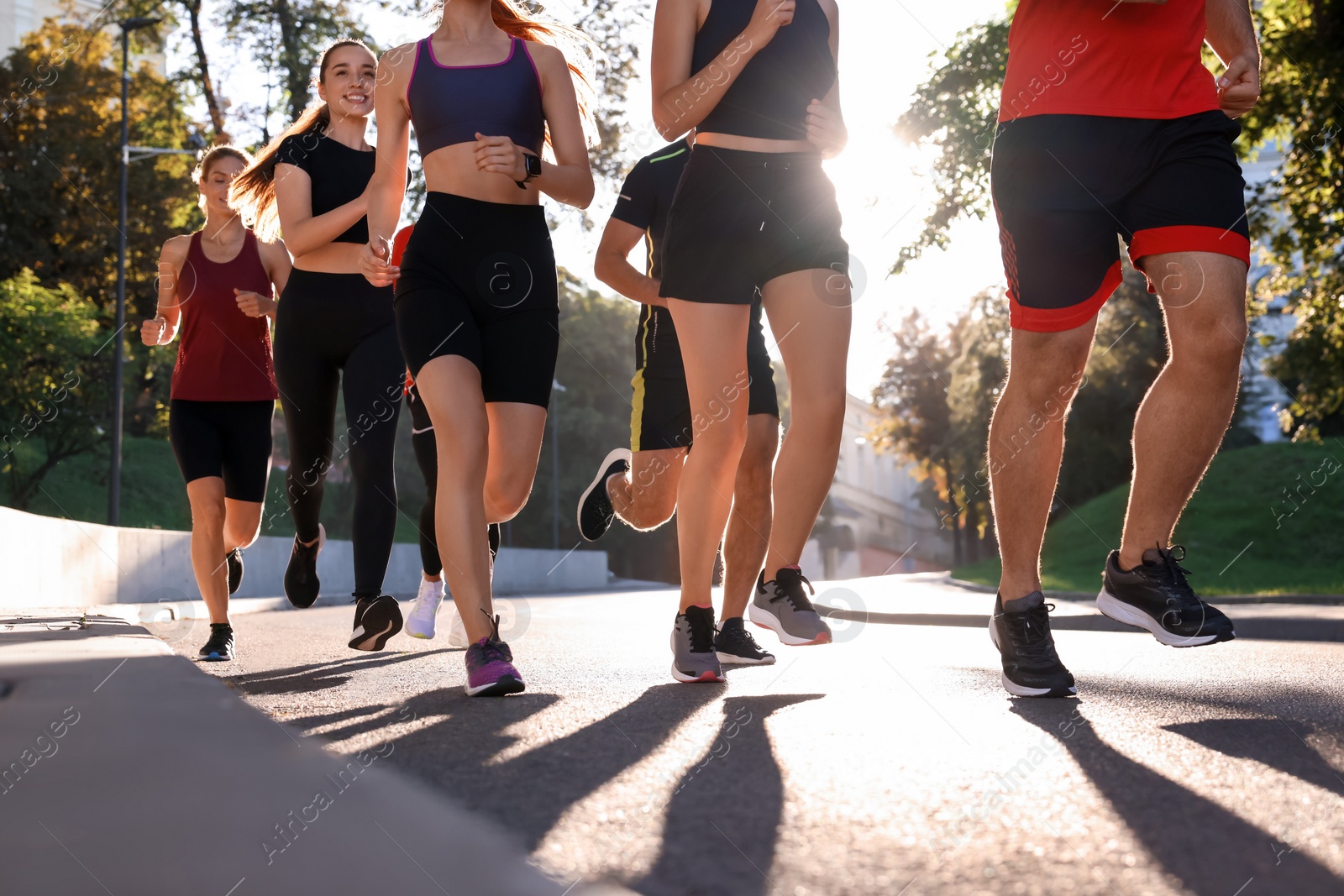 Photo of Group of people running outdoors on sunny day