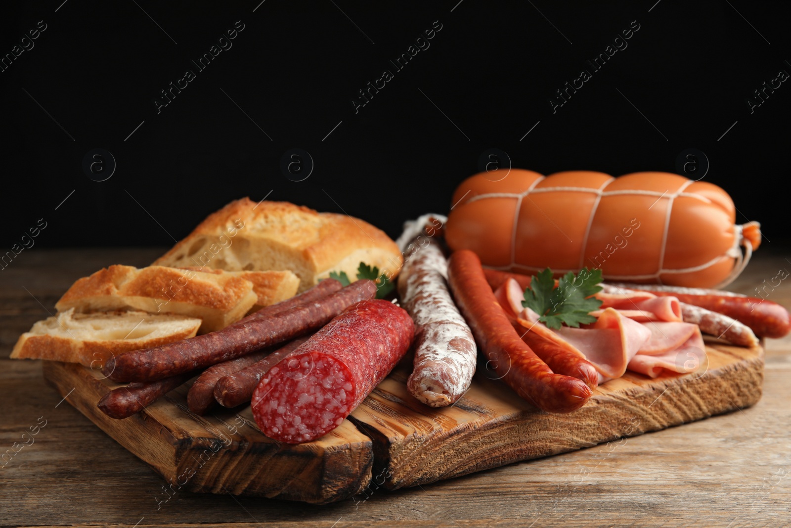 Photo of Different tasty sausages served on wooden table
