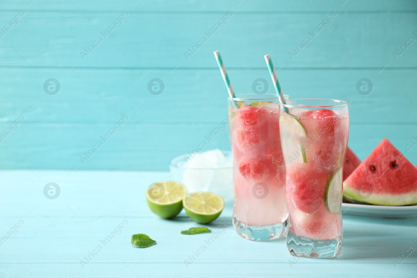 Photo of Delicious refreshing watermelon drink on blue wooden table. Space for text