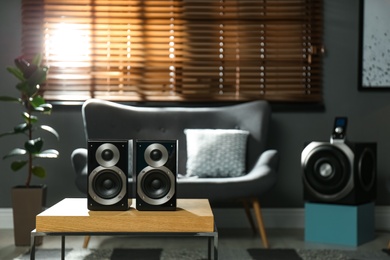 Modern audio speaker system on wooden table in living room. Interior design