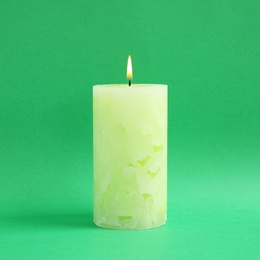 Alight scented wax candle on color background