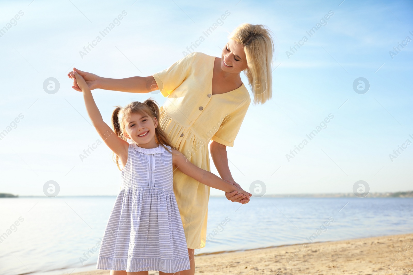 Photo of Happy mother and her child on beach. Spending time in nature