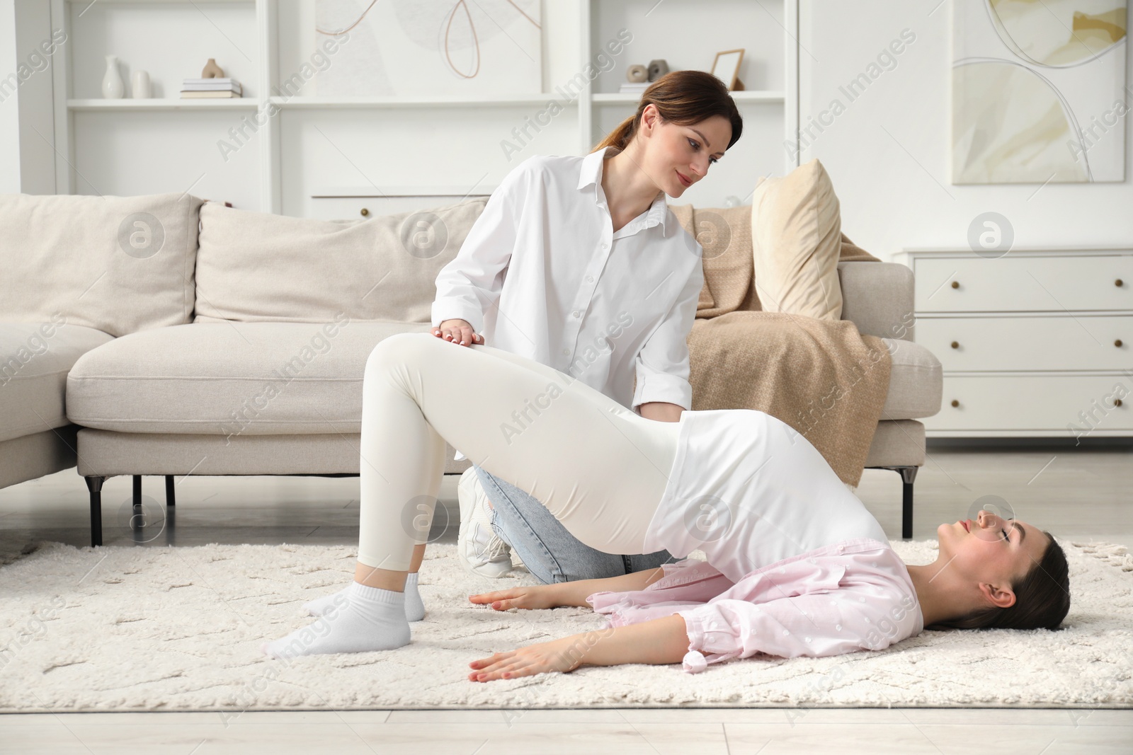 Photo of Doula working with pregnant woman at home. Preparation for child birth