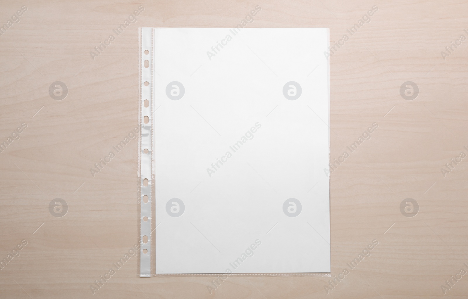 Photo of Punched pocket with paper sheet on wooden table, top view