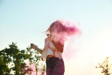 Photo of Happy woman covered with colorful powder dyes outdoors. Holi festival celebration