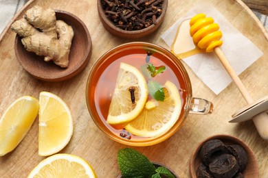 Tray with immunity boosting drink and ingredients on wooden table, top view