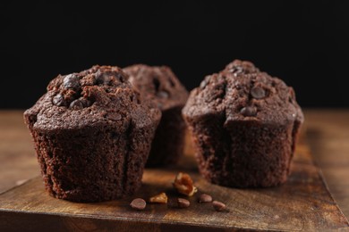 Delicious chocolate muffins on wooden table, closeup