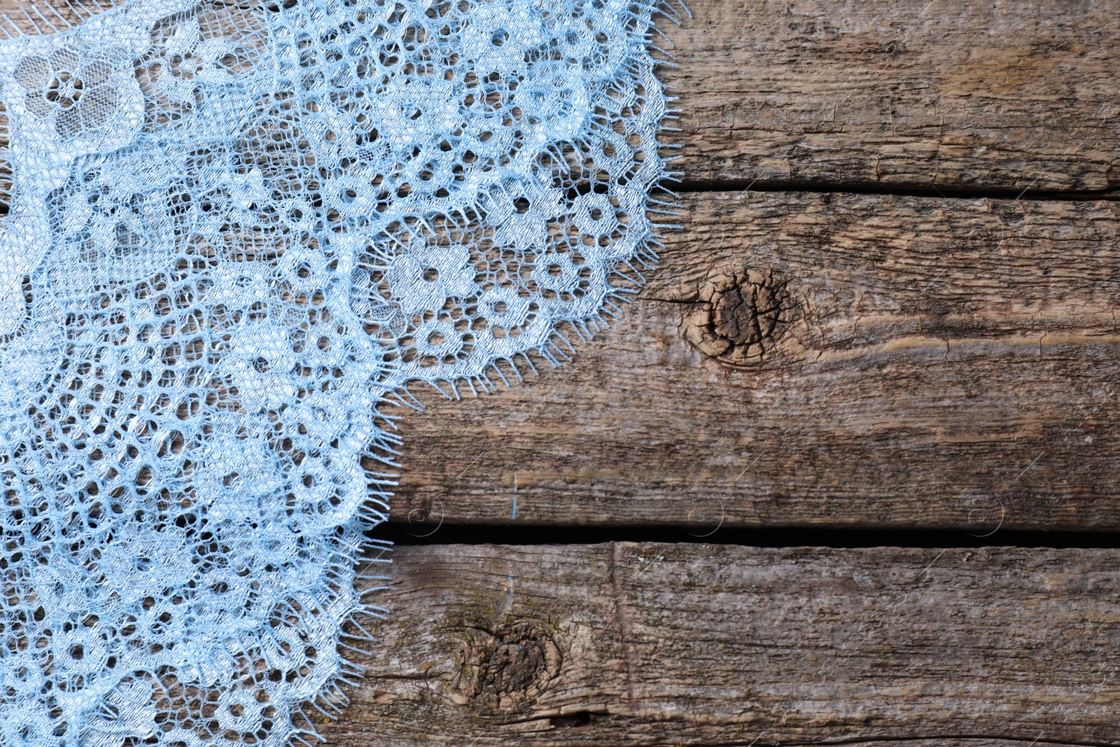 Photo of Beautiful lace on wooden table, top view. Space for text