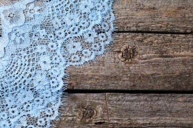 Photo of Beautiful lace on wooden table, top view. Space for text