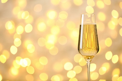 Photo of Glass of champagne against blurred lights. Space for text