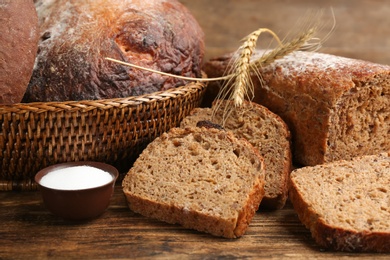 Photo of Tasty freshly baked bread on wooden table