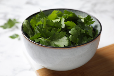 Photo of Fresh green parsley on white marble table, closeup