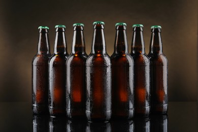 Photo of Many bottles of beer on table against dark background