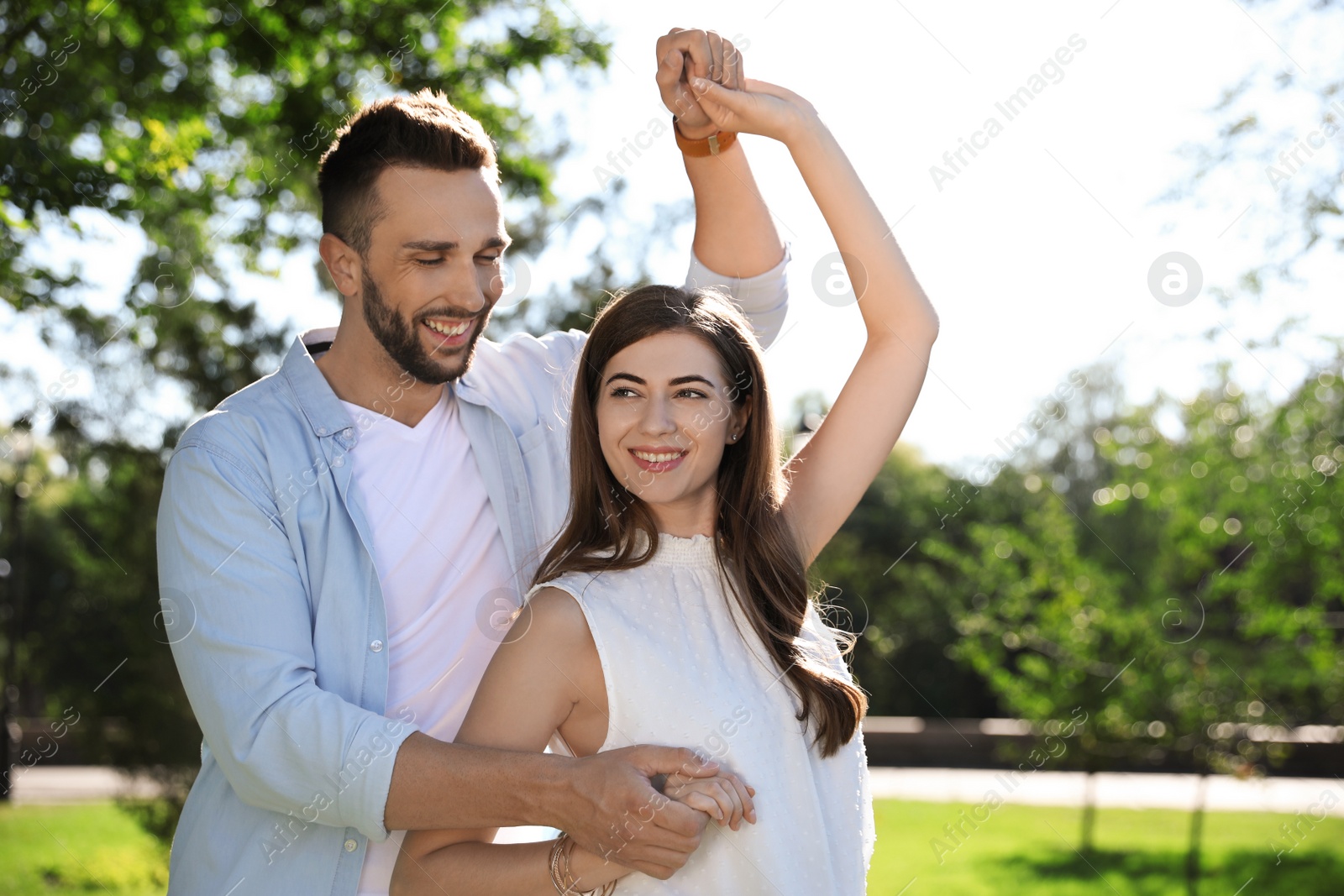 Photo of Lovely young couple dancing together in park on sunny day