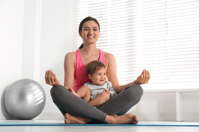 Young woman meditating with her son at home