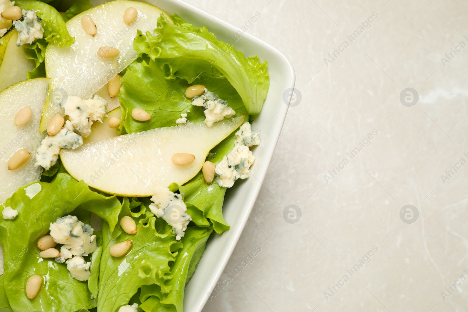 Photo of Fresh salad with pear on table, top view. Space for text