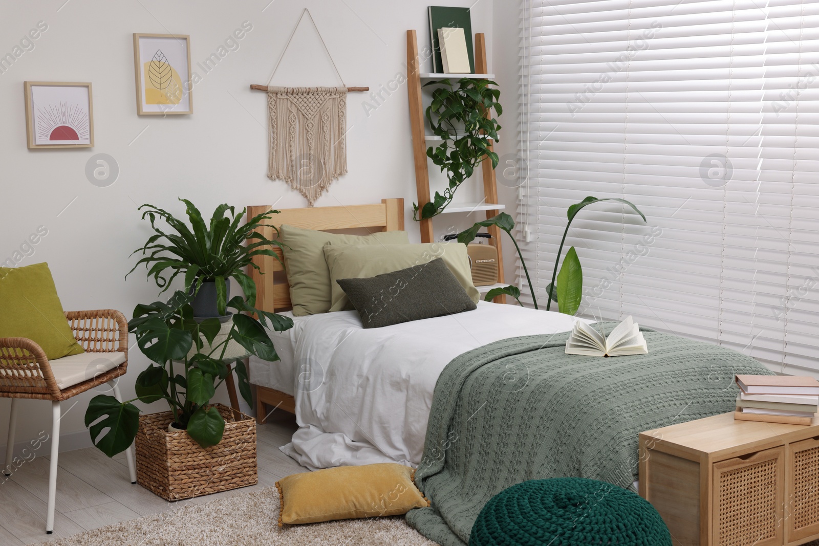 Photo of Large comfortable bed and potted houseplants in stylish bedroom. Interior design