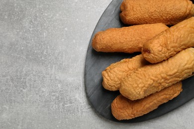 Delicious deep fried corn dogs with board on light grey table, top view. Space for text