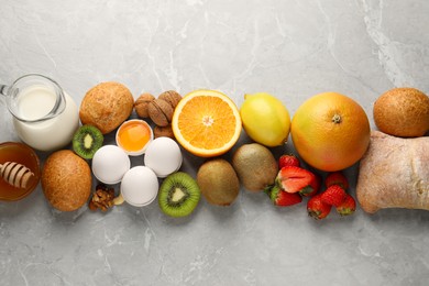 Photo of Allergenic food. Different fresh products on gray marble table, top view