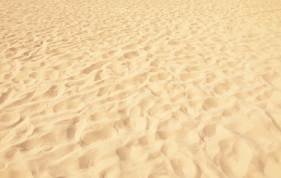 Photo of Golden beach sand on sunny day as background