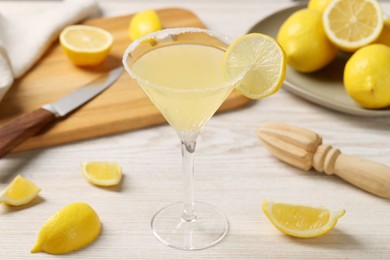 Photo of Lemon Martini cocktail and fresh fruits on white wooden table