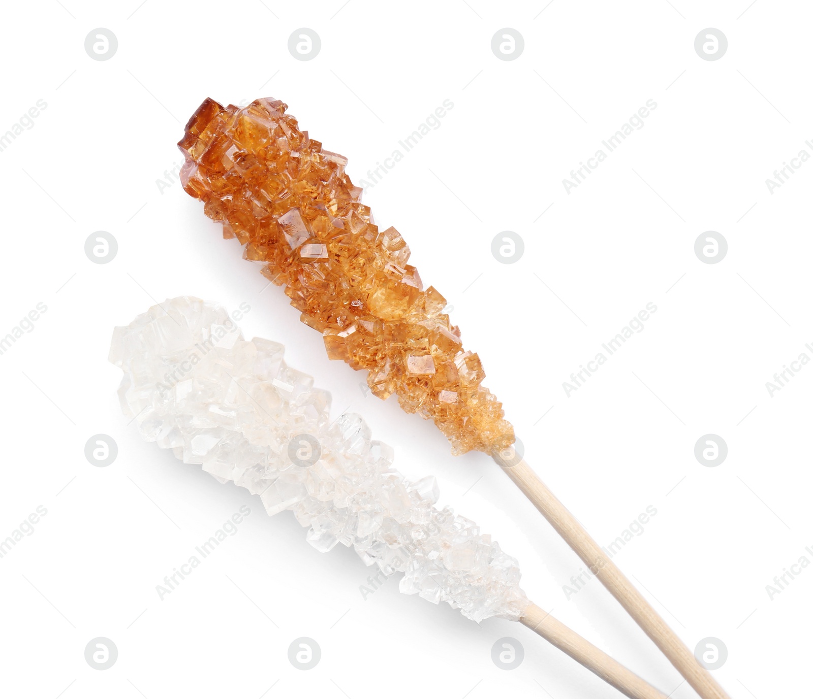 Photo of Wooden sticks with sugar crystals isolated on white, top view. Tasty rock candies