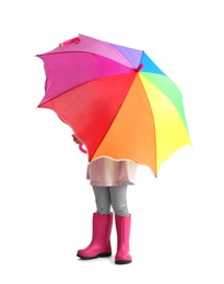 Little girl hiding under rainbow umbrella on white background