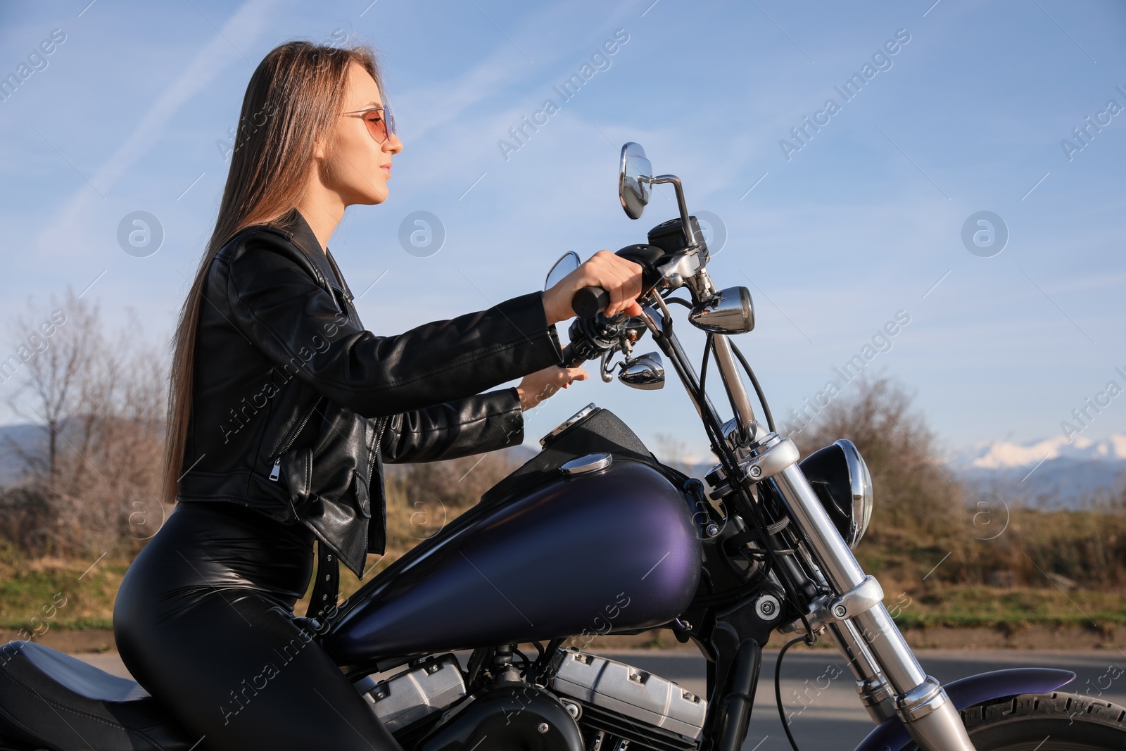 Photo of Beautiful woman riding motorcycle on sunny day