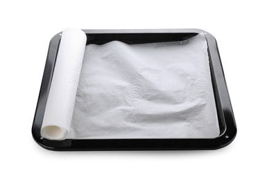 Photo of Baking pan with roll of parchment paper isolated on white