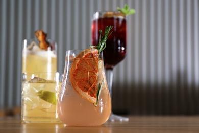 Glasses of delicious cocktails with vodka on wooden counter in bar