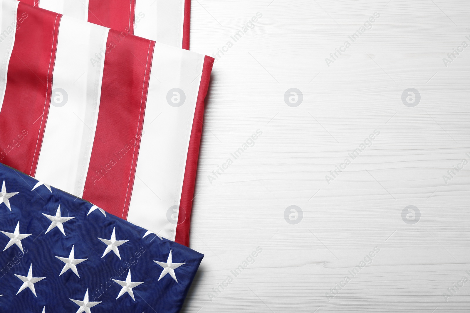 Photo of National flag of America and space for text on white wooden table, top view