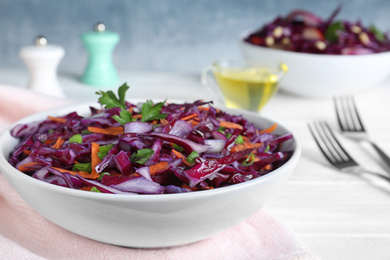 Photo of Fresh red cabbage salad served on white table, closeup