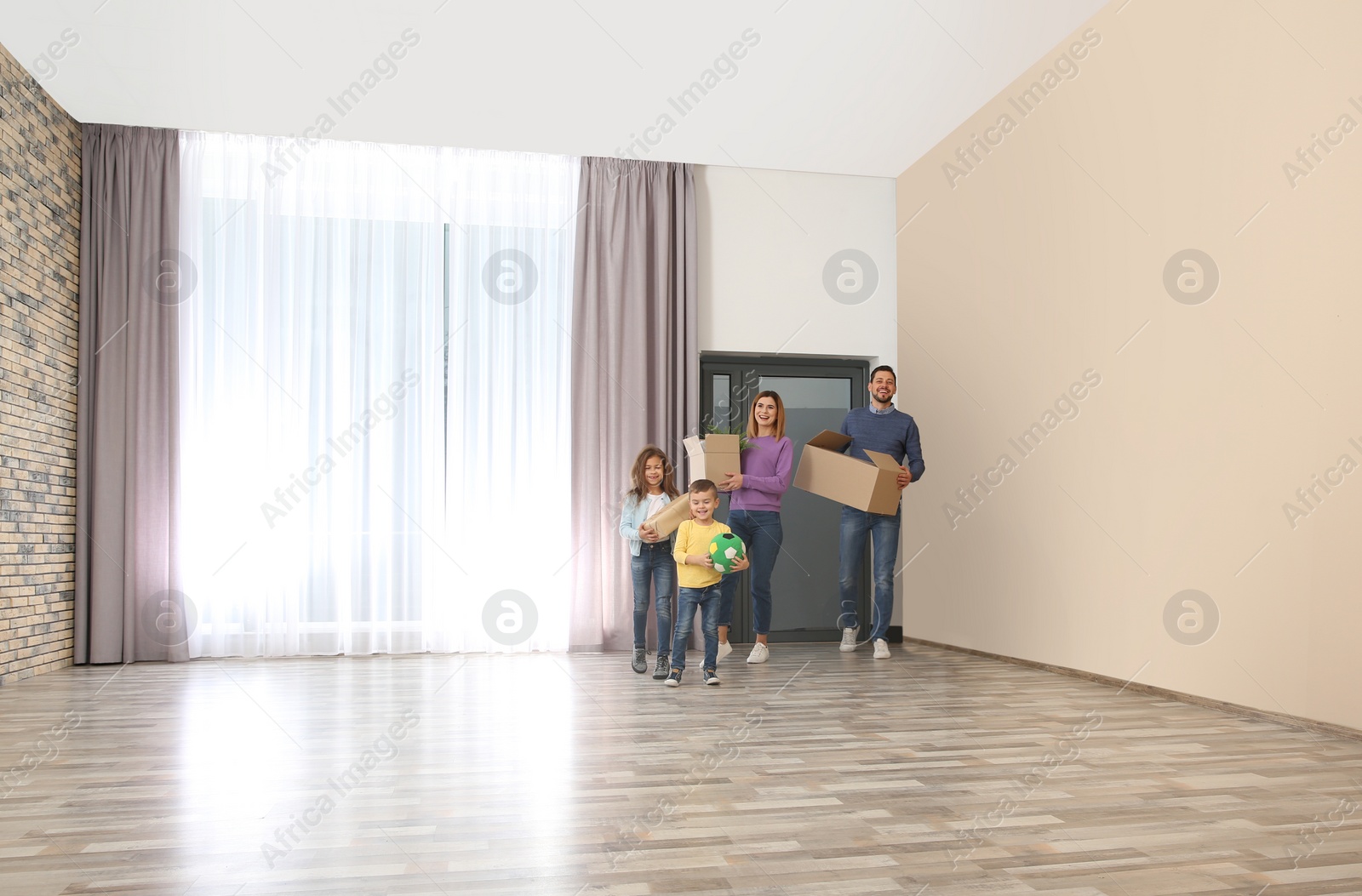 Photo of Happy family with moving boxes in their new house