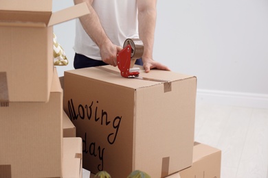 Man packing carton box indoors, closeup. Moving day