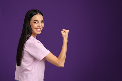 Photo of Strong woman as symbol of girl power on purple background, space for text. 8 March concept