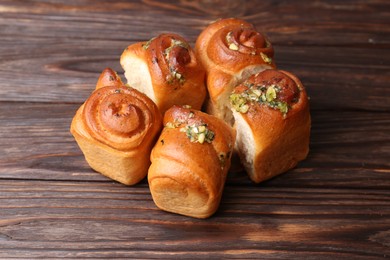 Photo of Tasty fresh pampushky. Traditional Ukrainian buns with garlic on wooden table