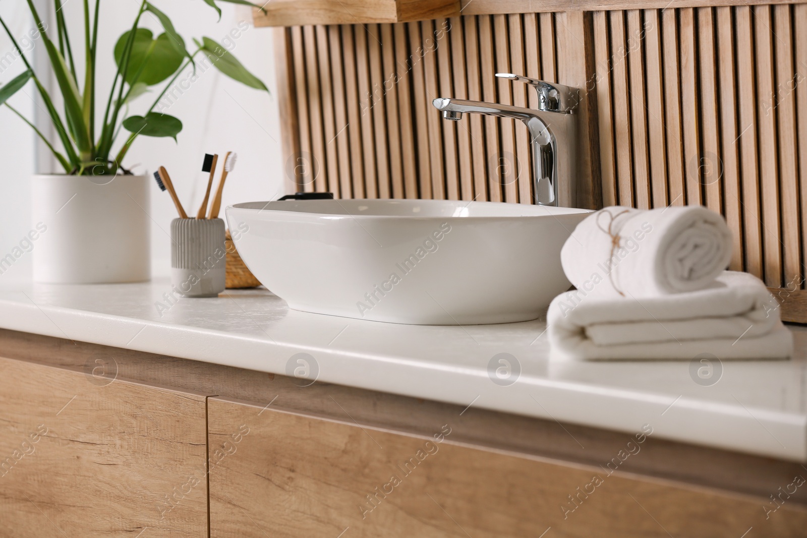 Photo of Stylish vessel sink near wooden wall in modern bathroom