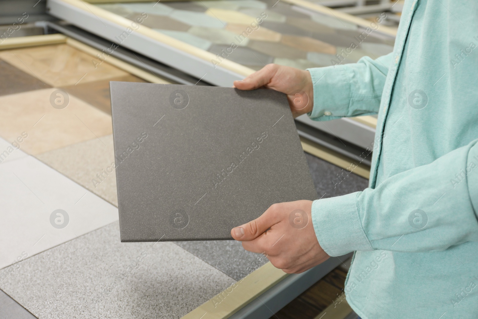 Photo of Man holding tile sample in store, closeup