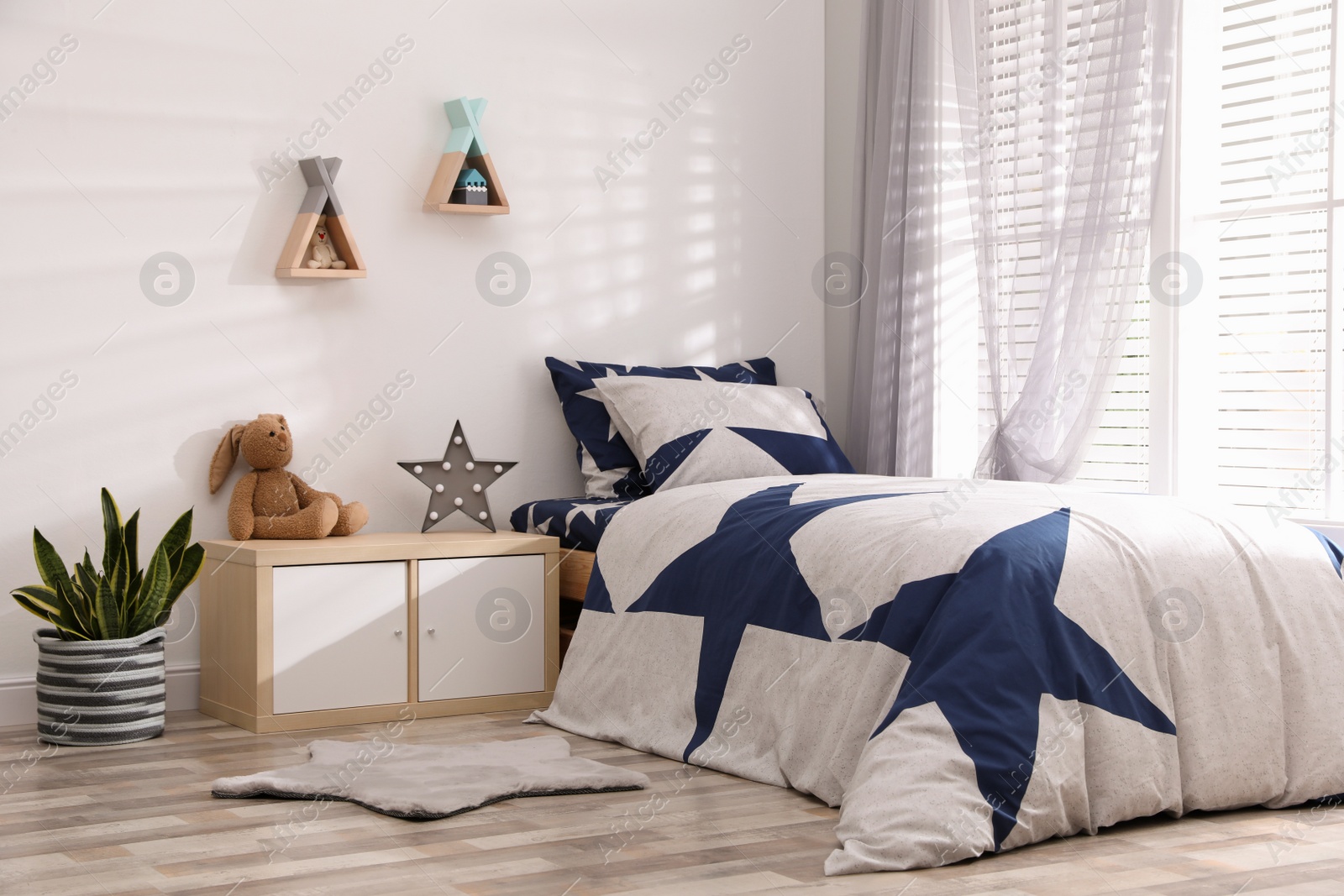 Photo of Bed with stylish linens in children's room