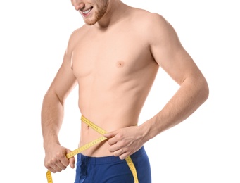 Young man with measuring tape showing his slim body on white background, closeup