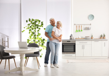 Photo of Happy mature couple dancing together in kitchen