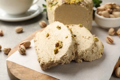 Photo of Tasty halva with pistachios on light grey table, closeup