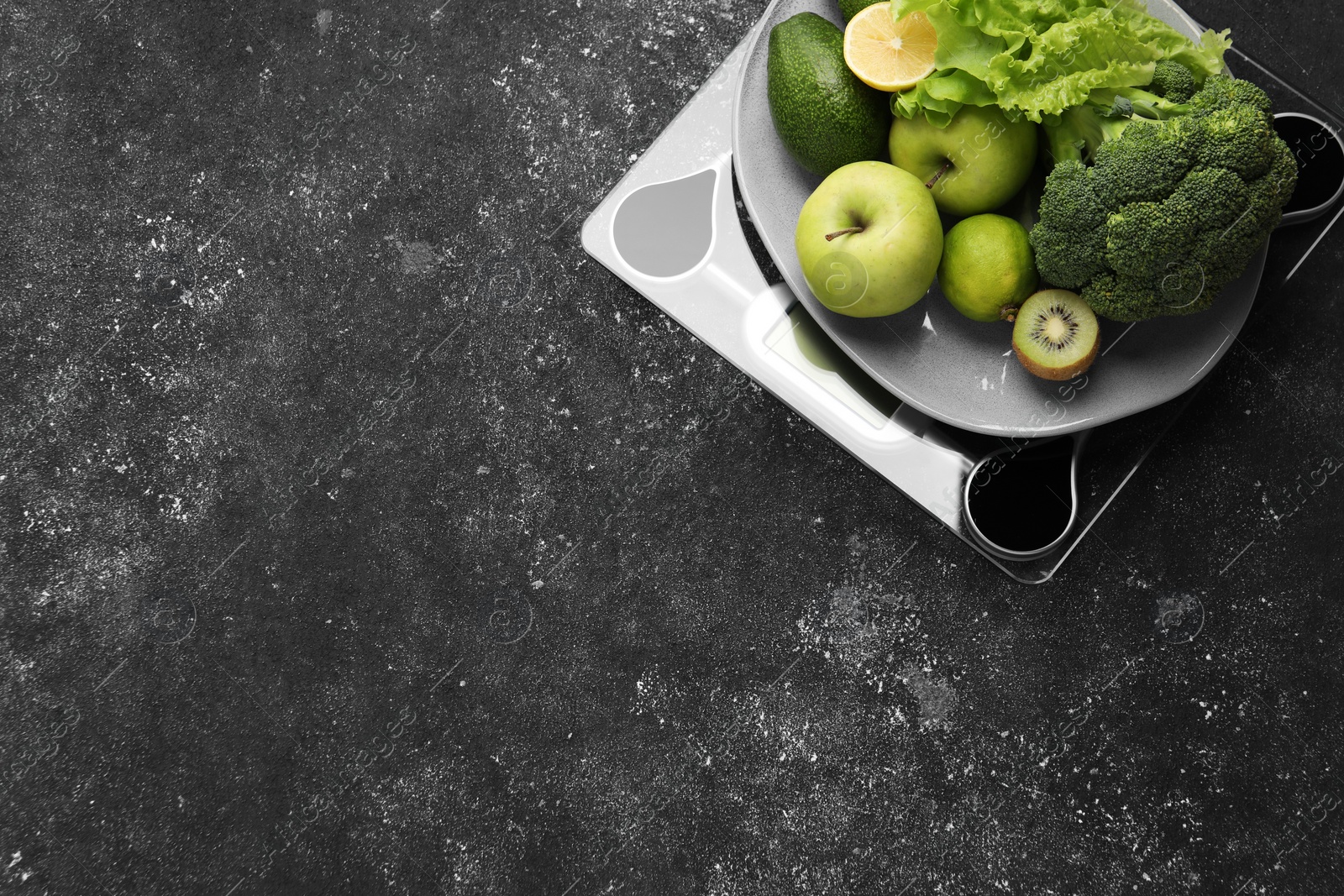 Photo of Healthy diet. Scale and fresh products on black textured table, top view with space for text