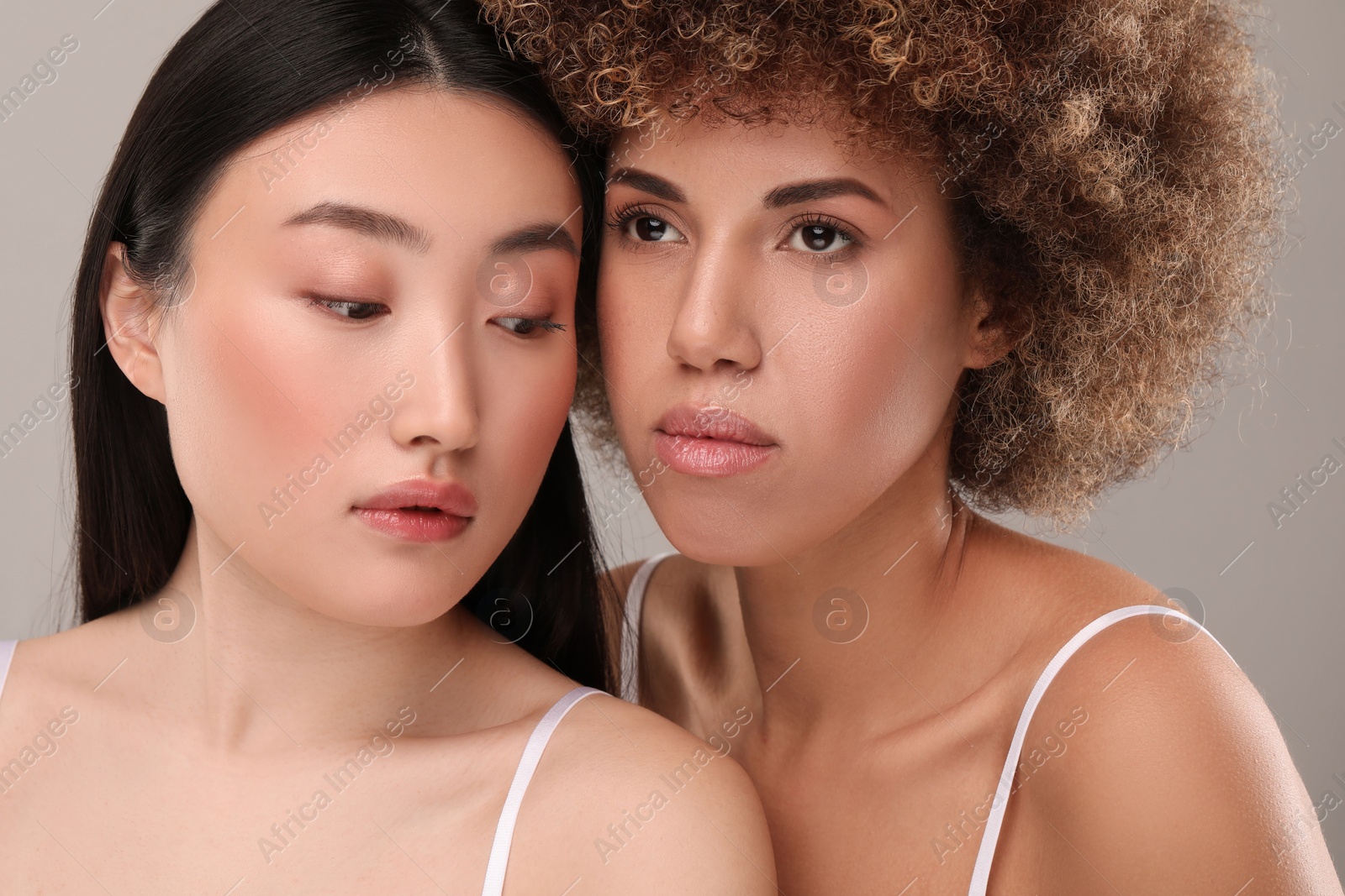 Photo of Beautiful young women with healthy skin on gray background