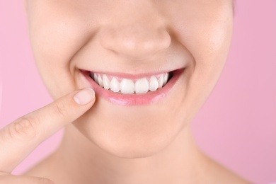 Young woman with beautiful smile on color background, closeup